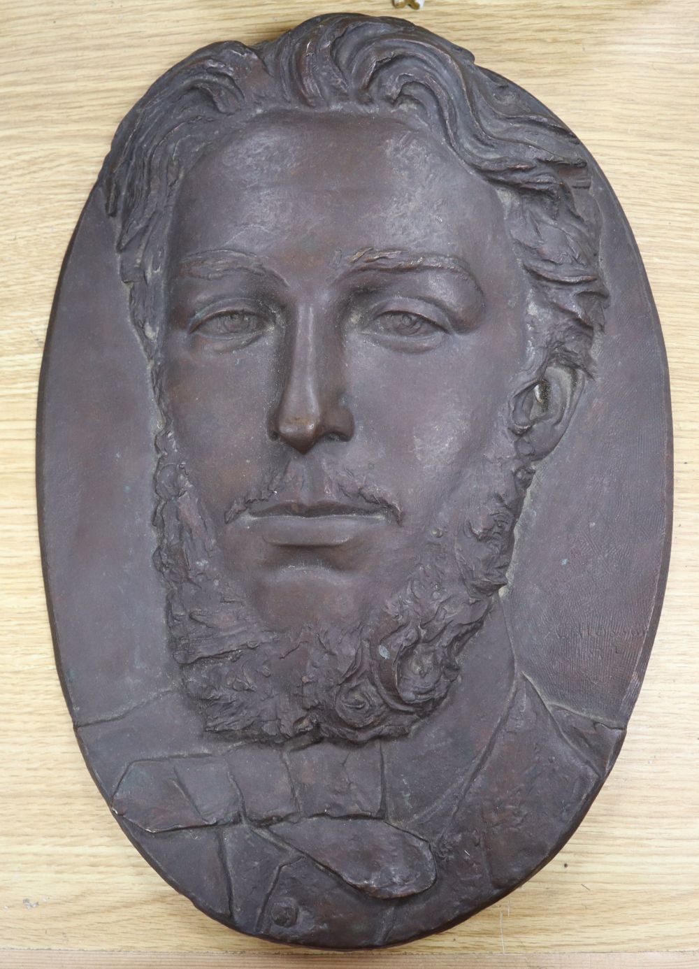 A bronze oval relief of a gentleman, signed A. Husson, dated 1872, length 37cm